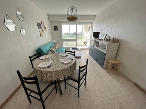 une table à manger et des chaises dans un salon dans l'établissement T2 à 150m de la plage avec loggia, parfait pour 5 pers. - FR-1-324A-37, à Saint-Hilaire-de-Riez