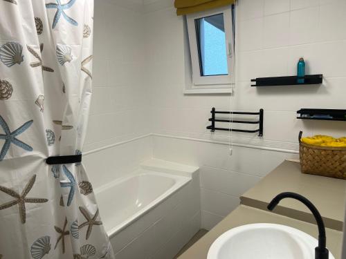 a bathroom with a tub and a sink and a shower curtain at Apartmán Vidiek in Spišská Teplica