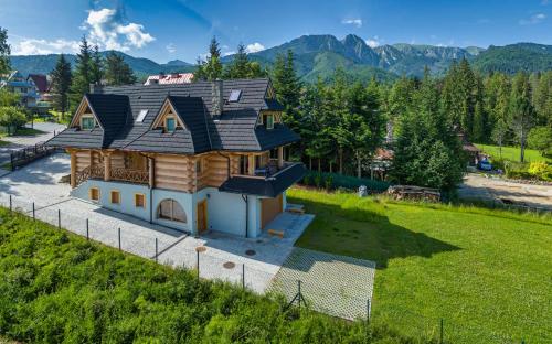 a house with a roof on top of a field at Chaty pod Giewontem in Zakopane