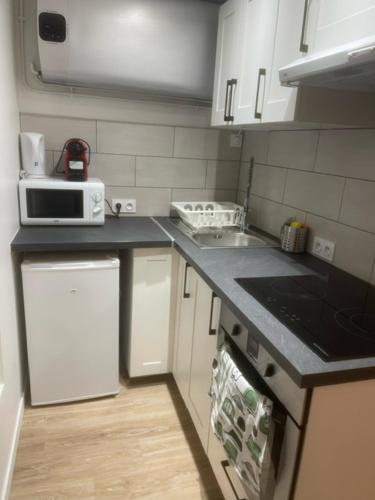 une cuisine avec des armoires blanches et un comptoir dans l'établissement Logement entier Montigny-les-Cormeilles - Près de Paris, à Montigny-lès-Cormeilles