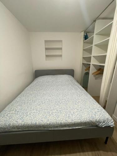 - un petit lit dans une chambre avec une étagère dans l'établissement Logement entier Montigny-les-Cormeilles - Près de Paris, à Montigny-lès-Cormeilles
