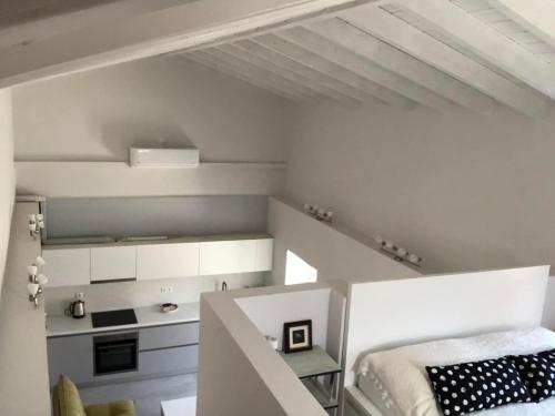 a white room with a bed and a kitchen at Bright and airy Village Studio Maisonette in Mytilinioí