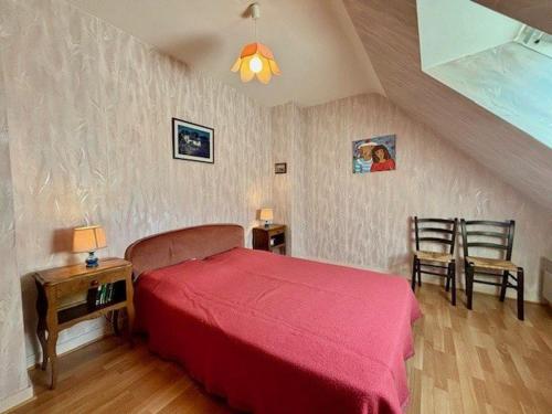 - une chambre avec un lit rouge et deux chaises dans l'établissement Maison calme 5 pièces à Saint-Pierre-Quiberon, proche plage, jardin clos, pour 8 personnes - FR-1-478-13, à Saint-Pierre-Quiberon