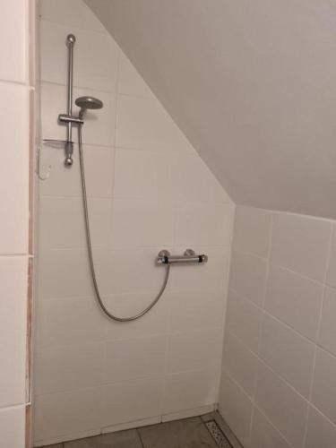 a shower in a white tiled bathroom at Chatka Terezka in Žilina