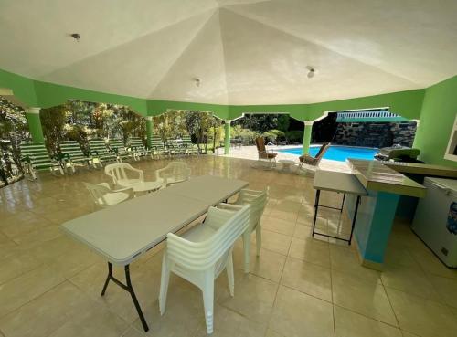 a dining room with a table and chairs and a pool at Villa Don Manuel in Villa Altagracia