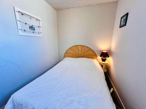 - une petite chambre avec un lit et une lampe dans l'établissement Quiberon - agréable 2 pièces avec vue sur le château, parking, animaux admis - FR-1-478-9, à Quiberon