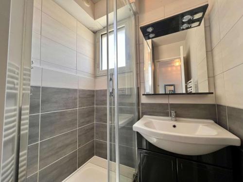 une salle de bain avec un lavabo et une douche en verre dans l'établissement Quiberon - agréable 2 pièces avec vue sur le château, parking, animaux admis - FR-1-478-9, à Quiberon