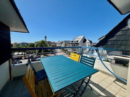 une terrasse avec une table bleue et des chaises sur un balcon dans l'établissement Appartement 3 pièces avec loggia, centre-ville Quiberon, 20m de la plage, animaux acceptés - FR-1-478-126, à Quiberon