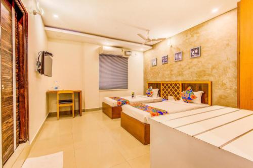 a hotel room with two beds and a tub at FabExpress Mayuri Residency in Bangalore
