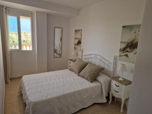 ein weißes Schlafzimmer mit einem Bett und einem Fenster in der Unterkunft Relax Nou Fontana 200M2 5min Beach in Jávea