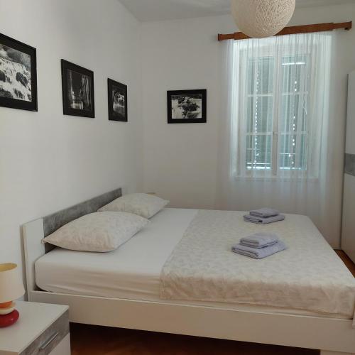 a white bed in a bedroom with a window at APP Old Garden House in Šibenik