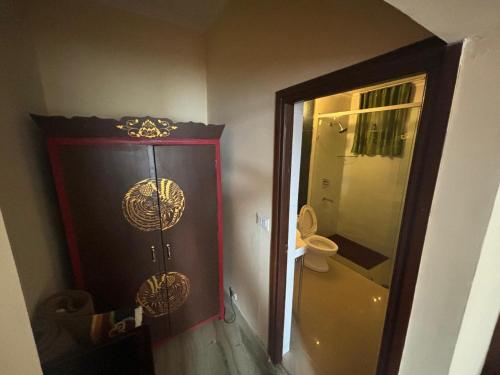 a bathroom with a shower and a door with a toilet at New Serkong House in Dharamshala
