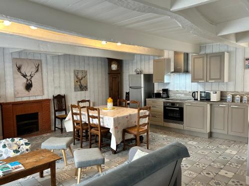 une cuisine avec une table et des chaises dans une pièce dans l'établissement 953 - Maison 10p proche d'Erquy - Sables d'Or., à La Bouillie