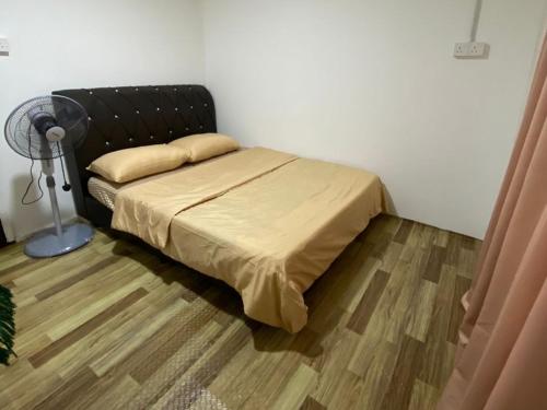 a bedroom with a bed with a black headboard at KK Homestay in Alor Setar
