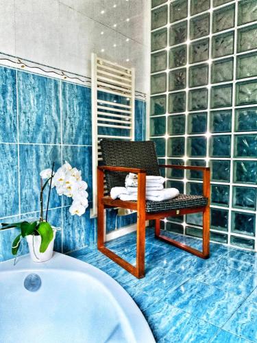 La salle de bains est pourvue d'une chaise et d'une baignoire. dans l'établissement Séjour au soleil avec piscine, à Vinon-sur-Verdon