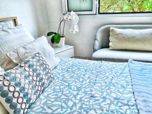 Cette chambre comprend un lit avec une couette bleue et une chaise. dans l'établissement Séjour au soleil avec piscine, à Vinon-sur-Verdon