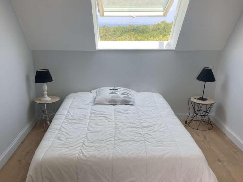 un lit blanc dans une chambre avec une fenêtre dans l'établissement Maison en pierre à Perros-Guirec avec grand jardin et WIFI - FR-1-368-235, à Perros-Guirec