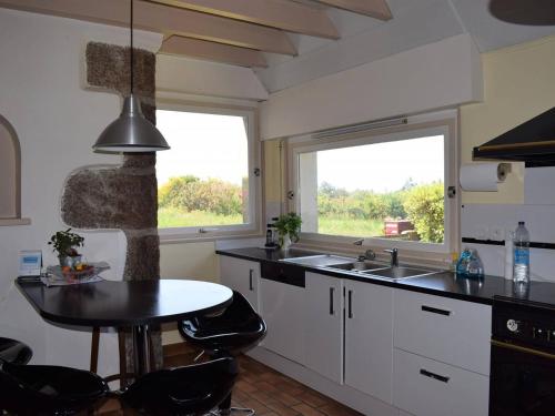 une cuisine avec un évier, une table et une fenêtre dans l'établissement Maison en pierre à Perros-Guirec avec grand jardin et WIFI - FR-1-368-235, à Perros-Guirec