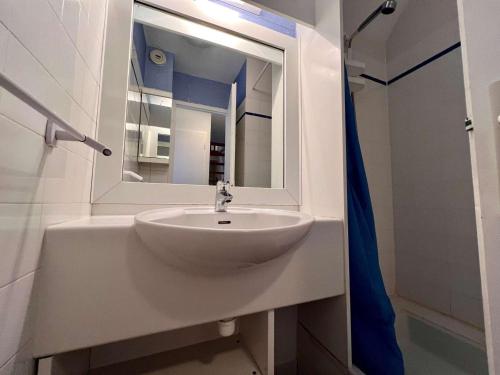 un lavabo blanc dans une salle de bain avec un miroir dans l'établissement Quiberon : Charmant T2 avec piscine, terrasse, parking, proche plage - 4 pers. - FR-1-478-174, à Quiberon