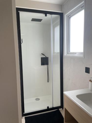 a shower with a glass door in a bathroom at Camping Le Mont César in Gouvieux