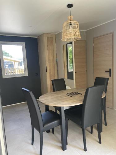 a dining room table with chairs and a chandelier at Camping Le Mont César in Gouvieux
