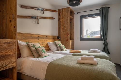 une chambre avec deux lits et une fenêtre dans l'établissement Hameau des Cornuts - Apartment B01, aux Gets