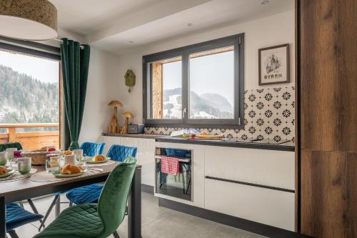 une cuisine avec une table et des chaises et une fenêtre dans l'établissement Hameau des Cornuts - Apartment B01, aux Gets