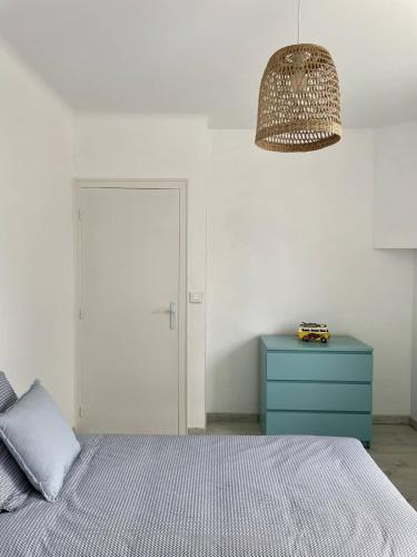 - une chambre avec un lit, une commode bleue et une lampe dans l'établissement Maison avec jardin clos et parking privé, à Plonéour-Lanvern