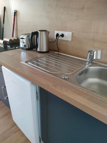 Il comprend une cuisine équipée d'un évier et d'un grille-pain. dans l'établissement Studio la voie verte Wi-Fi, télé, à Lorient