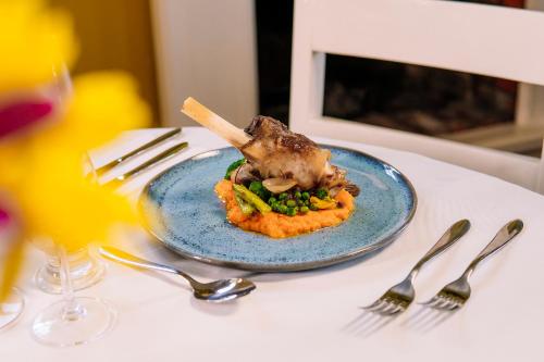 a plate of food with meat and vegetables on a table at Hotel Pousada da Neve in Nova Petrópolis