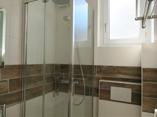 une douche avec une porte vitrée dans une salle de bain dans l'établissement Studio rénové avec WIFI, à 400m de la plage, centre de Trégastel - FR-1-368-299, à Trégastel