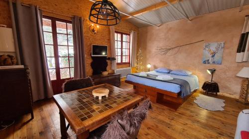a bedroom with a bed and a table in it at CHALET DES CHEVREUILS -les chalets de Montsermage in Moux-en-Morvan