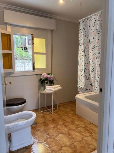 a bathroom with a toilet and a sink and a tub at Casona típica cántabra cerca de la playa de Gerra in La Revilla