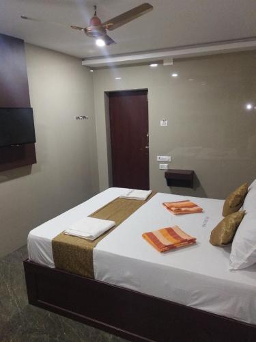 a bedroom with a large bed with towels on it at Hotel Temple Tower in Rāmeswaram