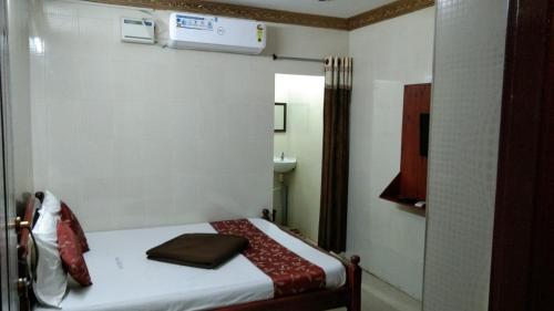 a small room with a bed and a sink at Hotel Temple Tower in Rāmeswaram