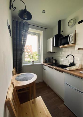 a small kitchen with a table and a window at Apartament Wilcze Zacisze in Biały Dunajec