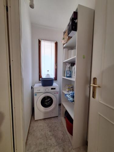 a laundry room with a washing machine and a window at Apposentu Sant'Antioco in SantʼAntìoco