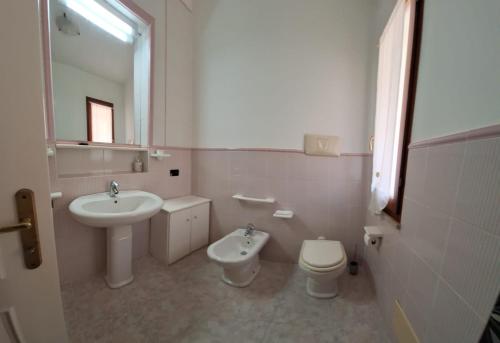 a white bathroom with a sink and a toilet at Apposentu Sant'Antioco in SantʼAntìoco