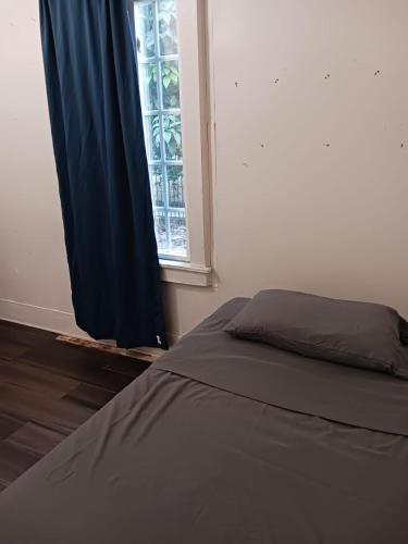 a bed sitting in a room with a window at Zen Home in Santa Ana