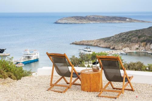 two chairs and a table with a view of the ocean at The Windmill Kimolos in Kimolos