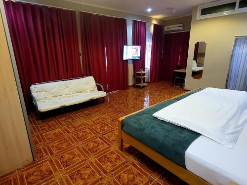 a bedroom with a bed and a chair and a television at Ghouse room A Ideal For Friends family And Corporate in Lateman