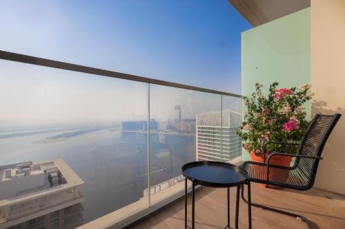 a balcony with a table and a view of a city at Stunning Beachfront 1BR Apartment in Palm Jumeirah By ĀYA Boutique in Dubai