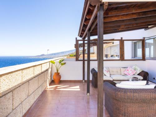 a balcony with a couch and a view of the ocean at Live Barranco Hondo Crisanto in Candelaria