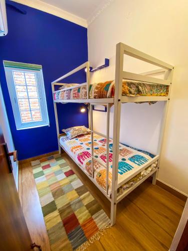 two bunk beds in a room with a blue wall at Comfort & Cozy, Villa in Orchha
