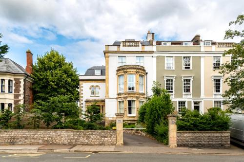 a large white house with a fence in front of it at Beech House - Urban Apartments in Bristol