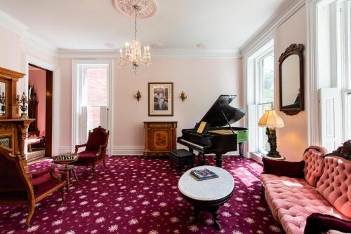 a living room with a couch and a piano at Central Park Bed & Breakfast in Louisville