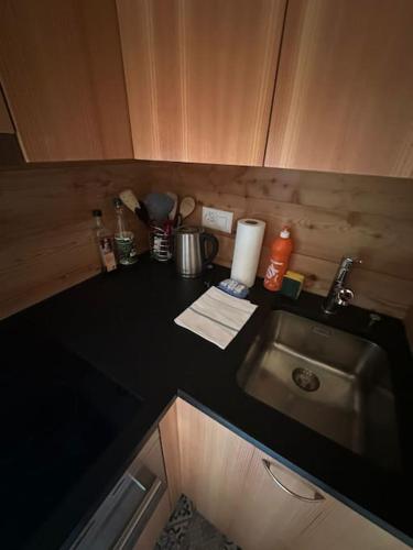 a kitchen with a sink and a black counter top at Rustic Alpine 1BR Getaway- Unwind and Reconnect in Reckingen - Gluringen