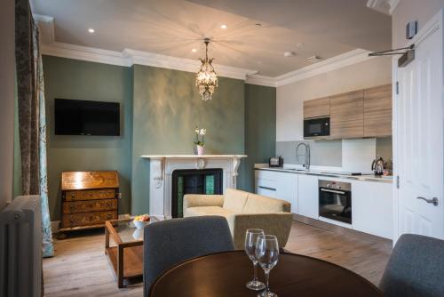 a living room with a couch and a table with chairs at Beech House - Urban Apartments in Bristol