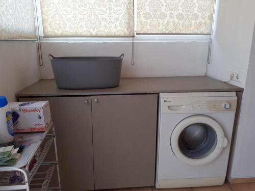 Un lavadero con lavadora y ventana. en La casa familiar, en Puerto Real