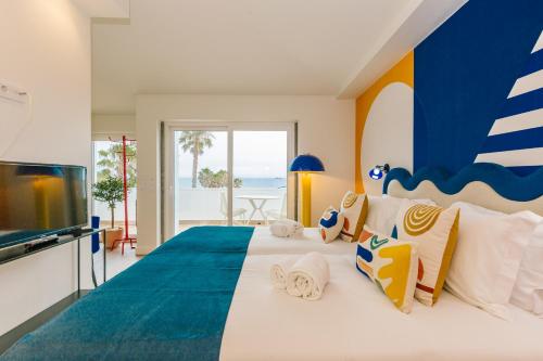 a bedroom with a large bed with a blue and white bedspread at RENT4REST Estoril Seafront Apartments in Estoril